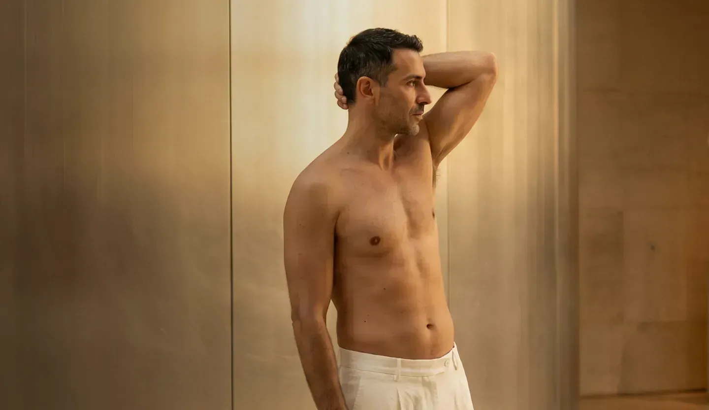 Man in a white t-shirt in a bright room – male breast surgery at Skulpturkliniken