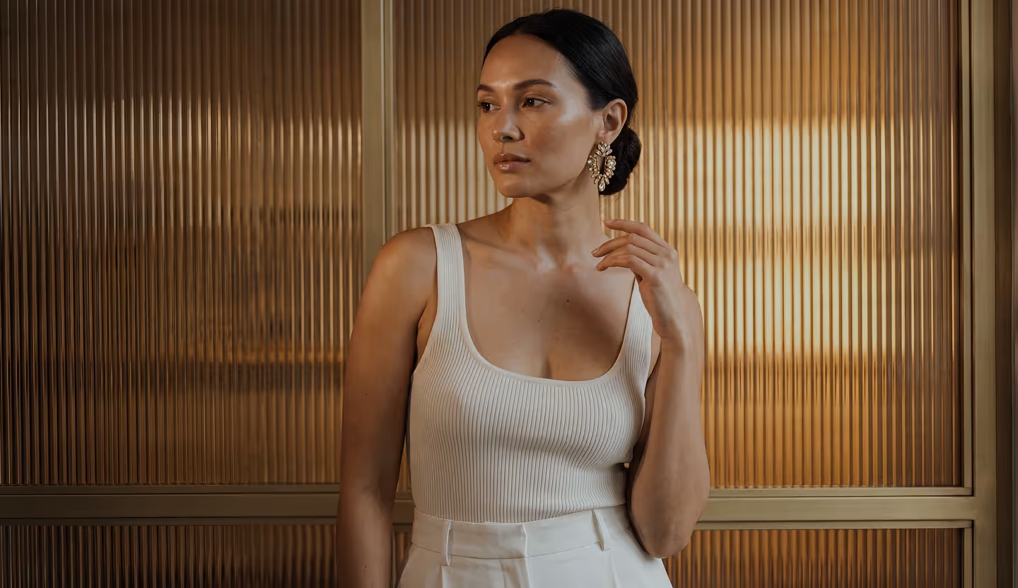 Woman in silk touching her décolletage – breast surgery at Skulpturkliniken