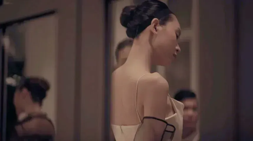 A woman in a white dress standing in front of a mirror