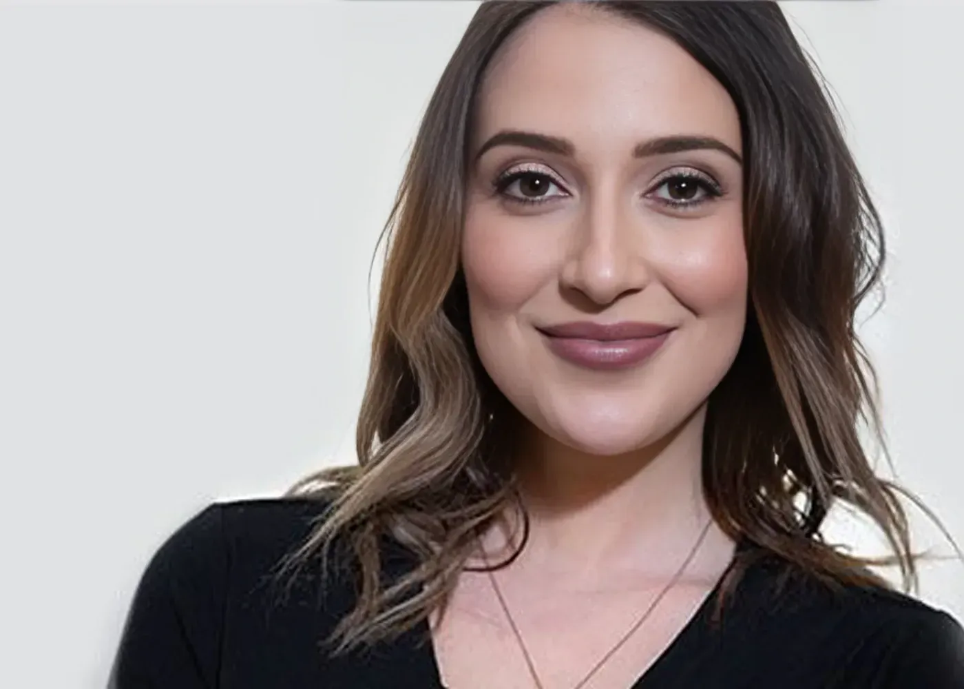 Professional headshot of Dr. Angela Salango, wearing a black V-neck top and gold necklace, smiling warmly at the camera.