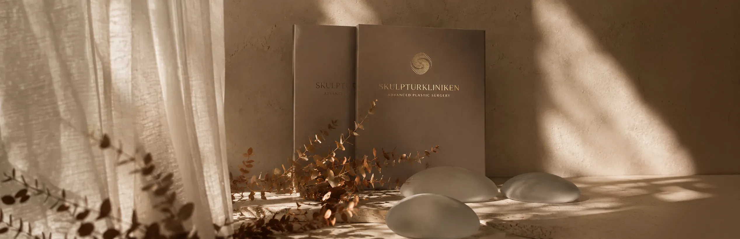 Skulpturkliniken branded folders and implant sizers on a sunlit shelf