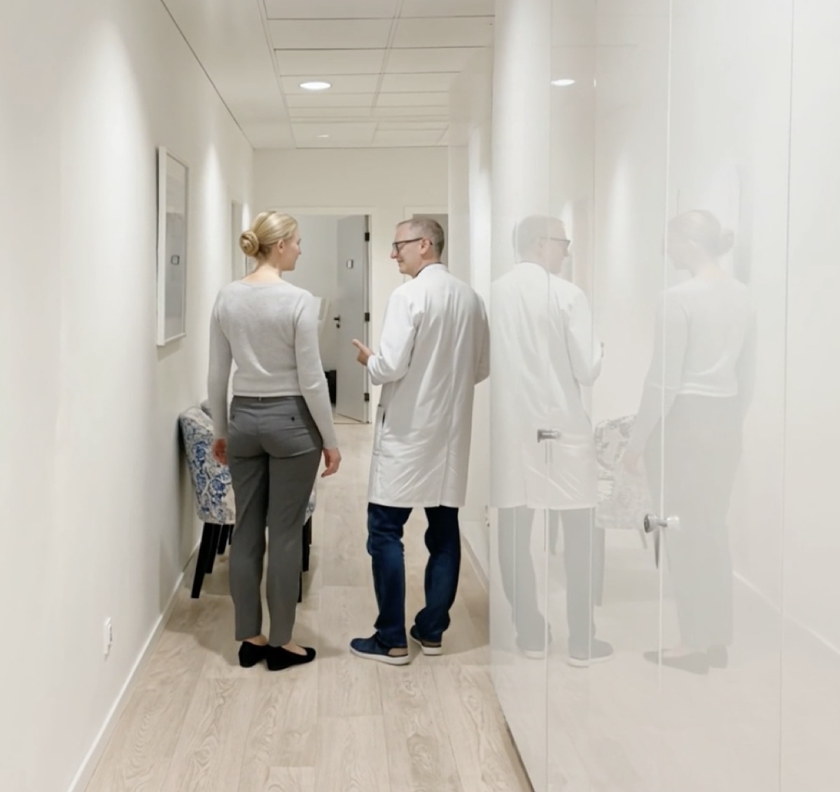Läkare och patient i klinikens korridor