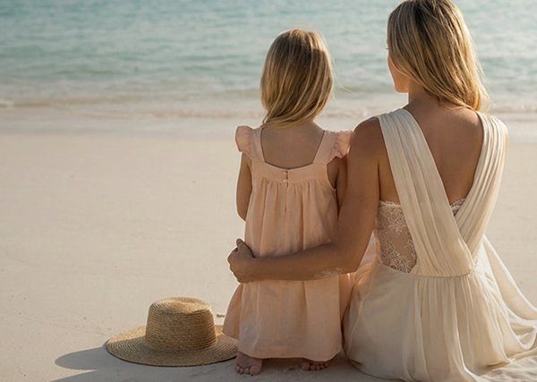 Mommy makeover patient in a flowing dress by the beach