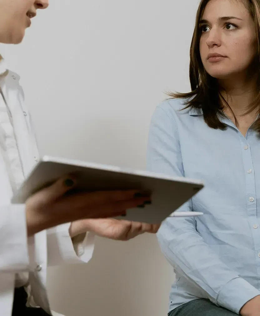 Två personer i ett samtal, en håller i ett dokument eller en tablet