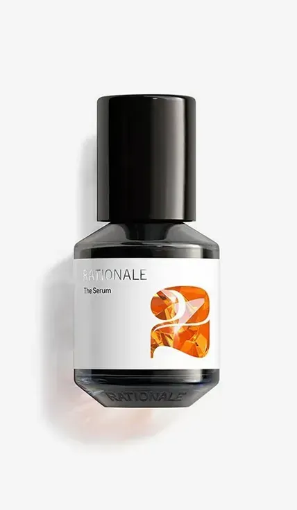 A bottle of cologne sitting on top of a white wall
