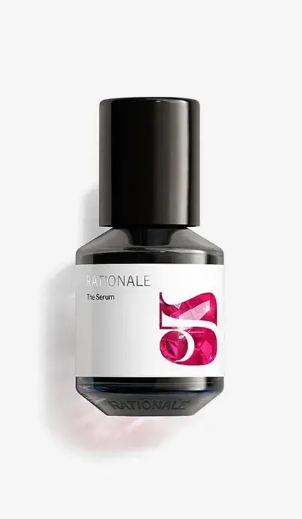 A bottle of cologne sitting on top of a white wall