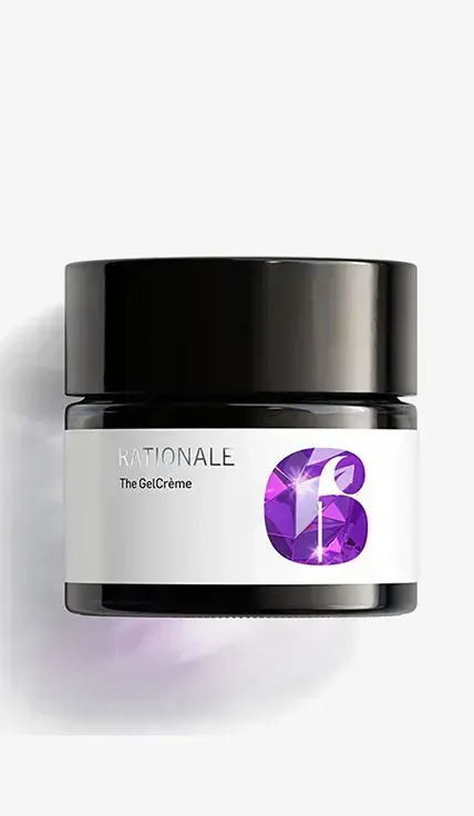 A jar of purple gel sitting on top of a white wall