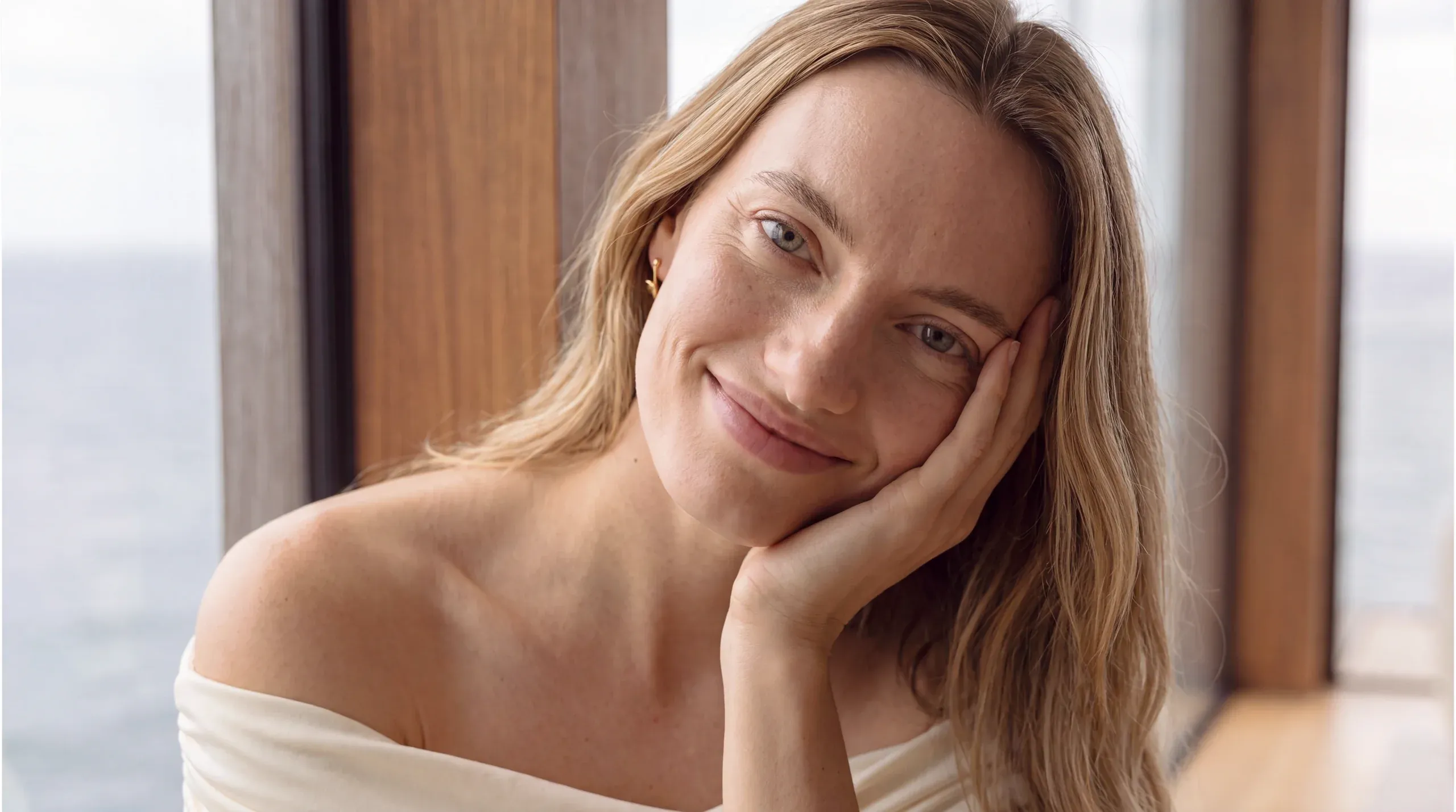 Person meditating by a window with an ocean view – longevity and wellness care at Skulpturkliniken