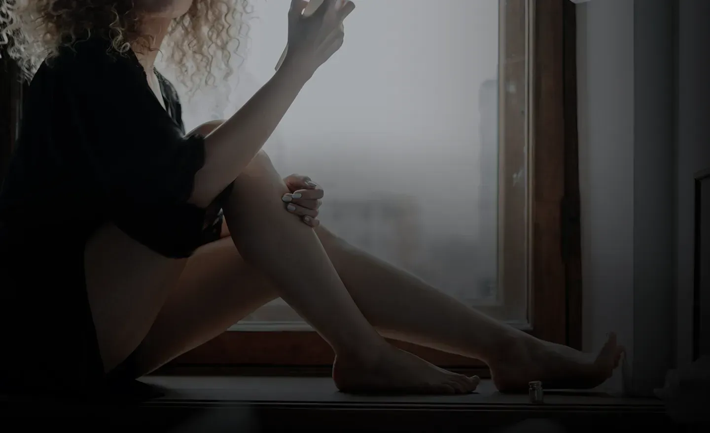 A woman sitting on a window sill